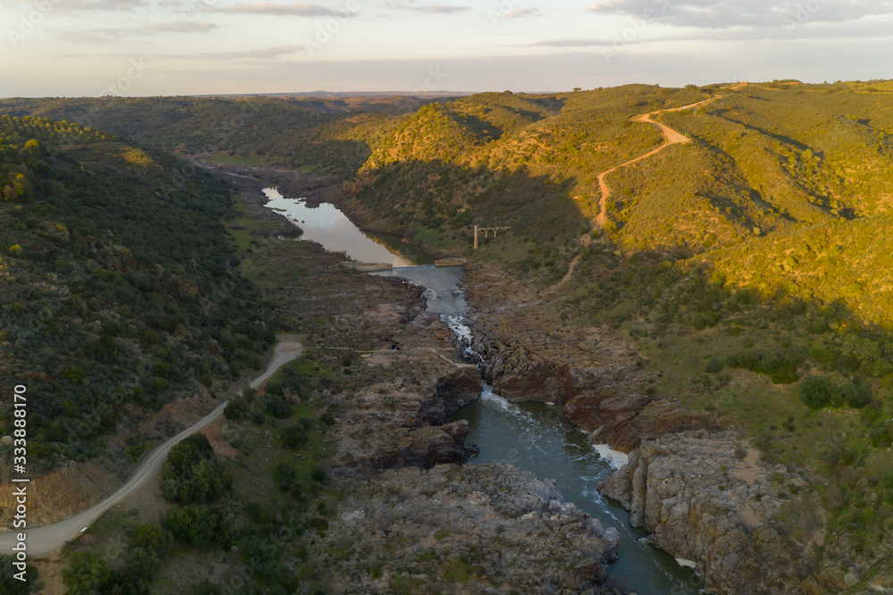 Pulo do Lobo waterfall drone aerial view with river guadiana and beautiful green valley landscape at sunset in Mertola Alentejo, Portugal
