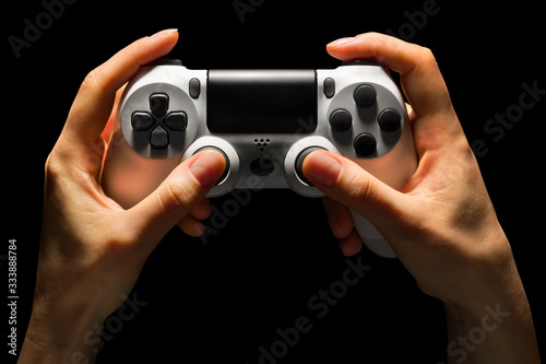 Hyman hands holding white video game gamepad isolated on a black background