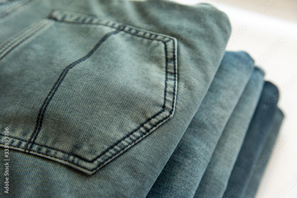 A lot of different blue jeans in the shop. Denim clothes store