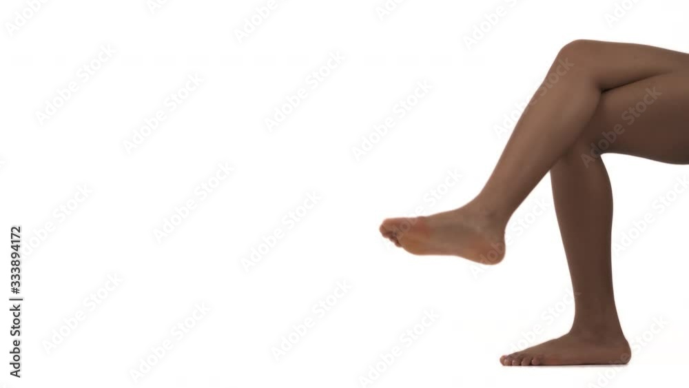 Sexy African woman sitting with crossed legs. Isolated on white background