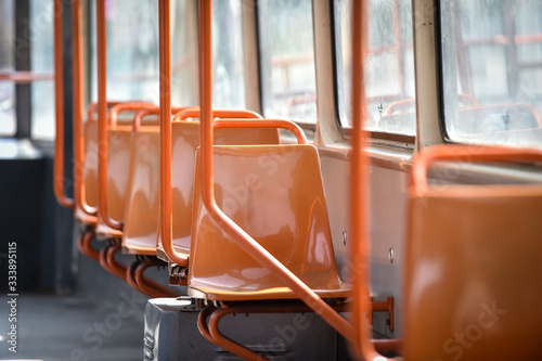 Obraz na płótnie Empty orange chairs in an empty public tram during coronavirus pandemic