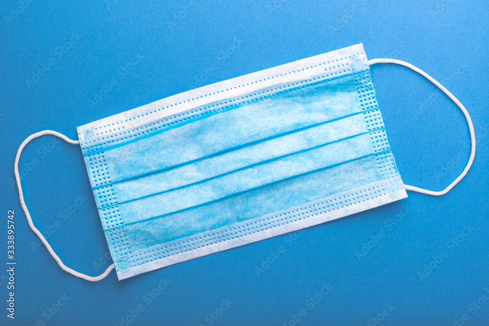 Medical mask on a blue background, close-up, protection of the virus. Medical mask on a blue background, close-up, protection of the virus.