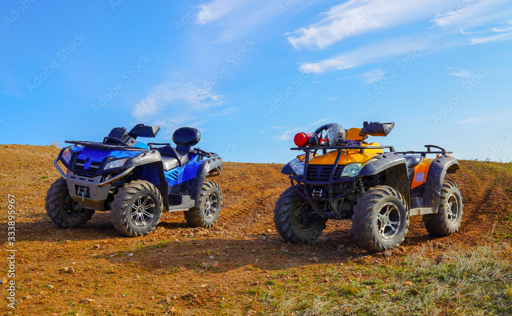 Two atv quad motorbikes standing on the top of mountain. sunny weather. leisure tourism hobby concept. outdoor adventures Two atv quad motorbikes standing on the top of mountain. sunny weather. leisure tourism hobby concept. outdoor adventures