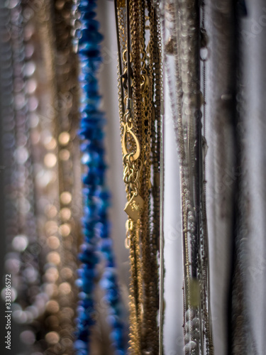 Isolated close up of a hand made chain jewelry rack filled with a wide variety of colorful jewels- Israel