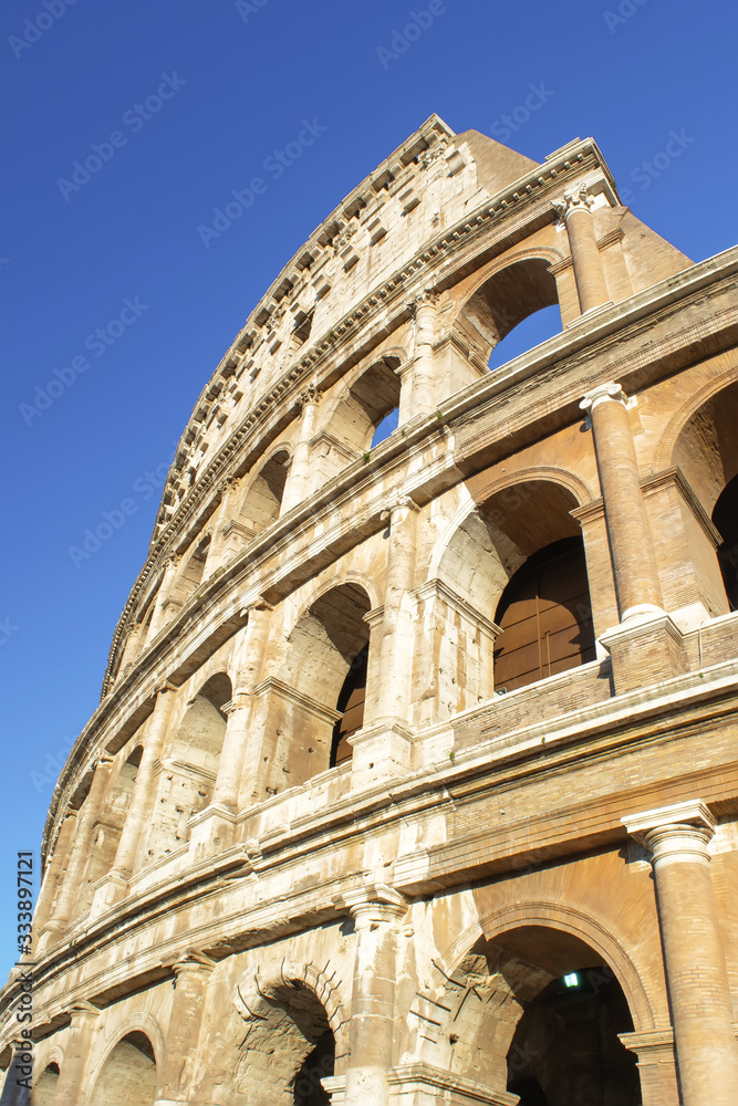 Part of Rome Colosseum at blue sky. Vertical image