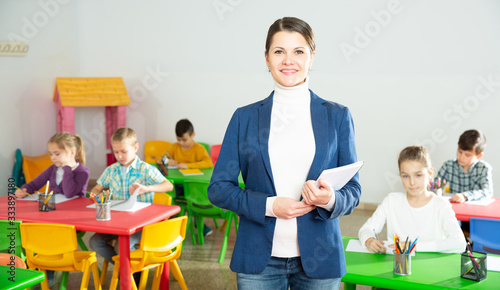 Portrait of friendly female teacher standing in classroom