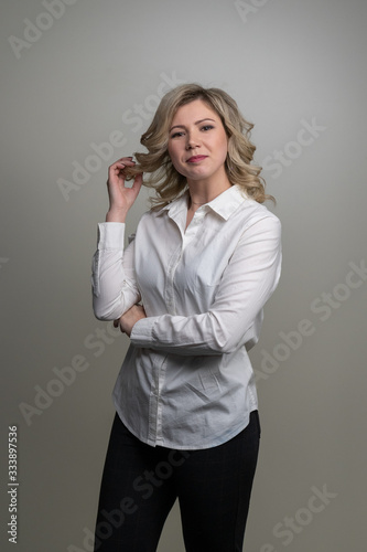 Obraz na płótnie 30 years old woman with blond hair in a white shirt posing w salonie