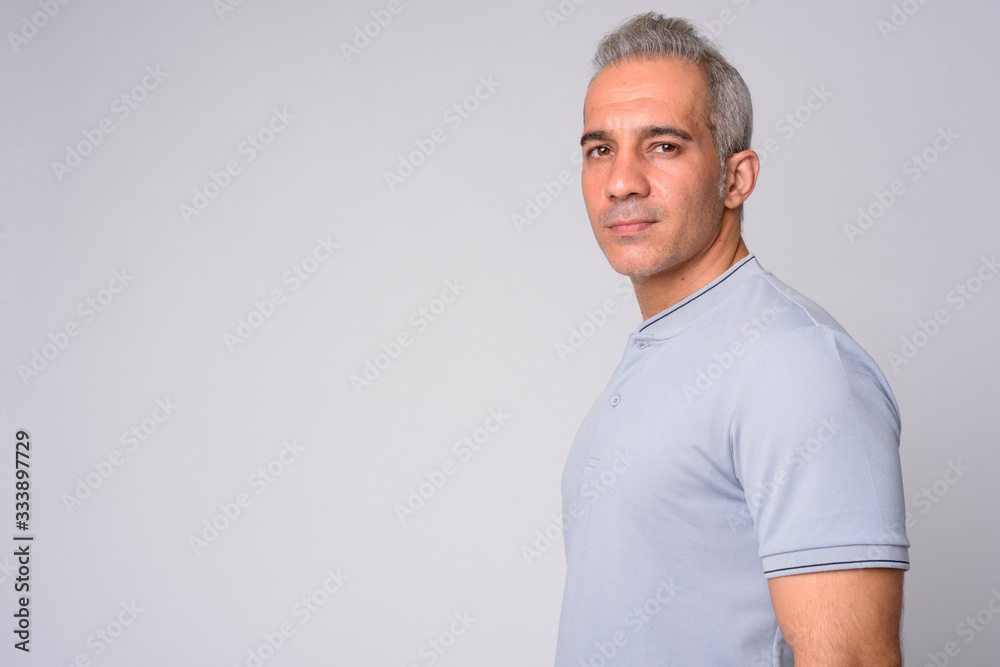 Profile view of handsome Persian man looking at camera Profile view of handsome Persian man looking at camera