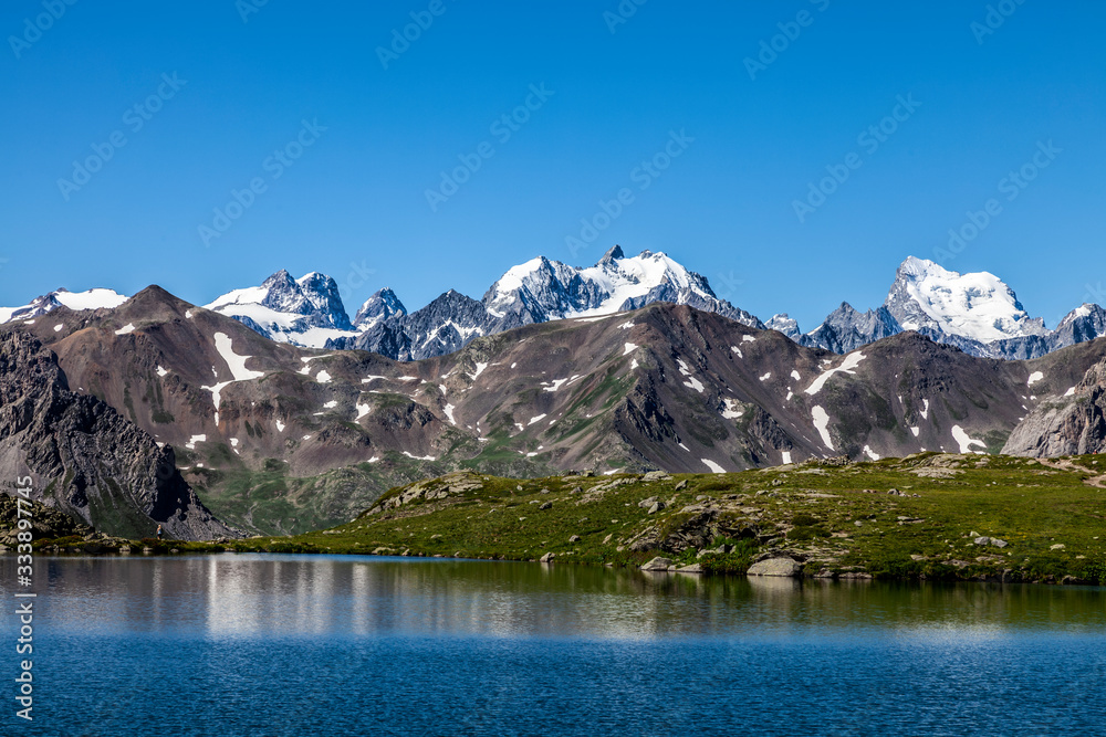 View of the Ecrins Massif with Barre des Écrins (4102m) and Mont Pelvoux (3932m) from Snake Lake (248m) located on Claree Valley in Nevache, Hautes Alpes, France