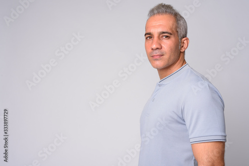 Profile view of handsome Persian man looking at camera