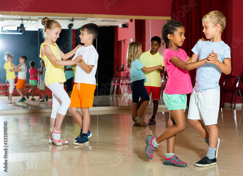 Group of cheery children dancing salsa dance