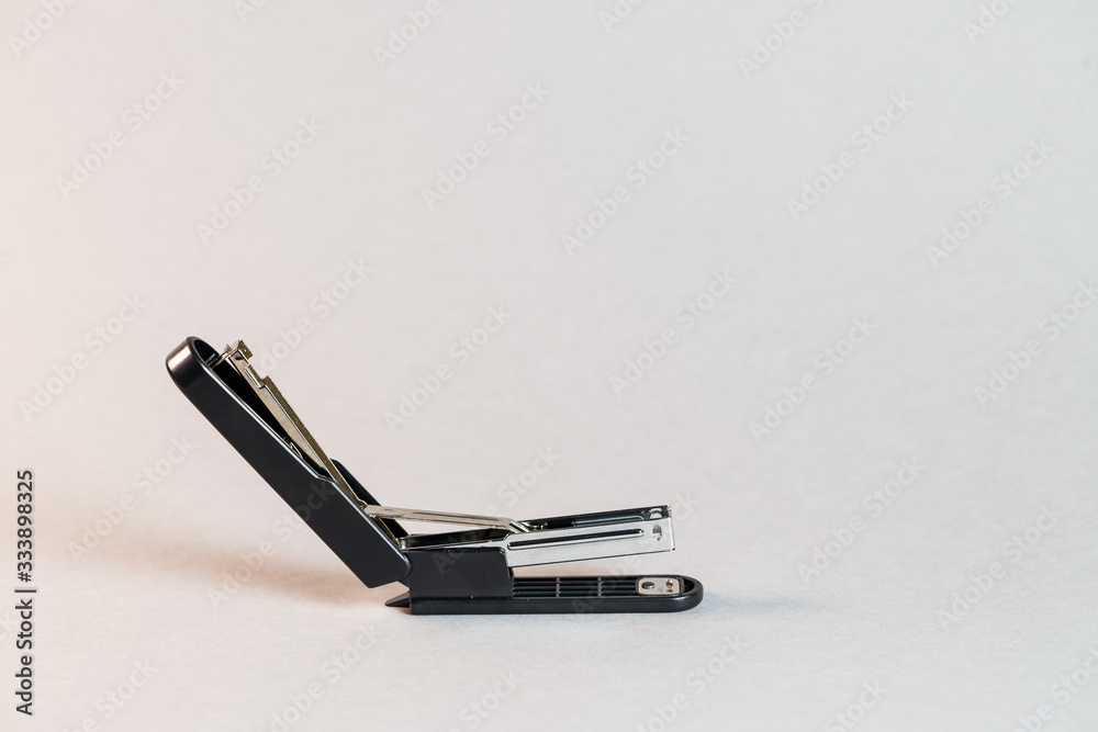 black stapler for fastening papers on a gray background black stapler for fastening papers on a gray background