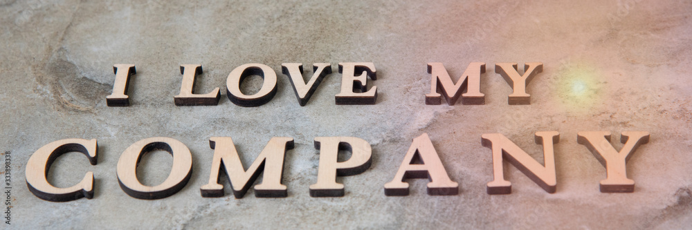 I love my company , writen wooden letters on stone background I love my company , writen wooden letters on stone background