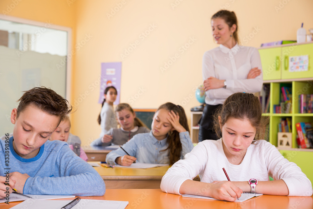 Fototapeta premium School kids studying in classroom with teacher