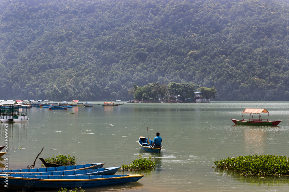 Obraz premium boaters sail a small boat without tourists on the lake. Countries empty without tourists because of the threat of coronavirus. travel agencies were left without customers, the impact to your business