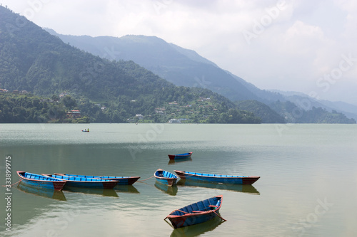 small boats of different colors of paint, on the surface of a clear lake.No tourists in a tourist vacation destination.Borders closed due to coronavirus and fewer tourists harming business