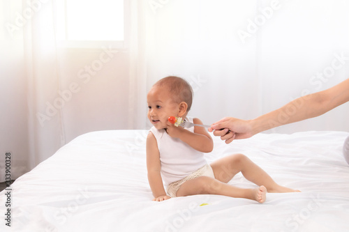 Fotografie Toddler child refuse, ignore, disgust vegetable or fruit tomato from mother, mom