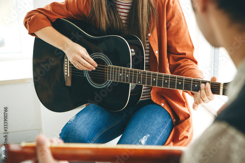Learning to play the guitar. The teacher explains to the student the basics of playing the guitar. Individual home schooling or extracurricular lessons.