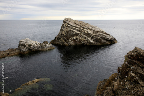 Portknockie (Scotland), UK - August 01, 2018: Coastal landscape at Bow Fiddle Rock sea arch, Portknockie, Scotland, Highlands, United Kingdom photo