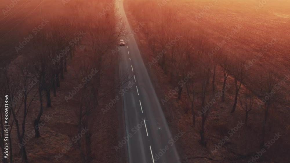 FEW SHOOTS MONTAGE. Fast red sport car goes on the road between trees on sunset, driver turn gearbox transmission, air aerial drone shoot motor rews