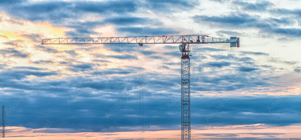 banner construction crane on a sunset background, clouds.