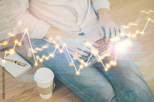 Forex graph with businessman working on computer in office on background. Concept of analysis. Double exposure.