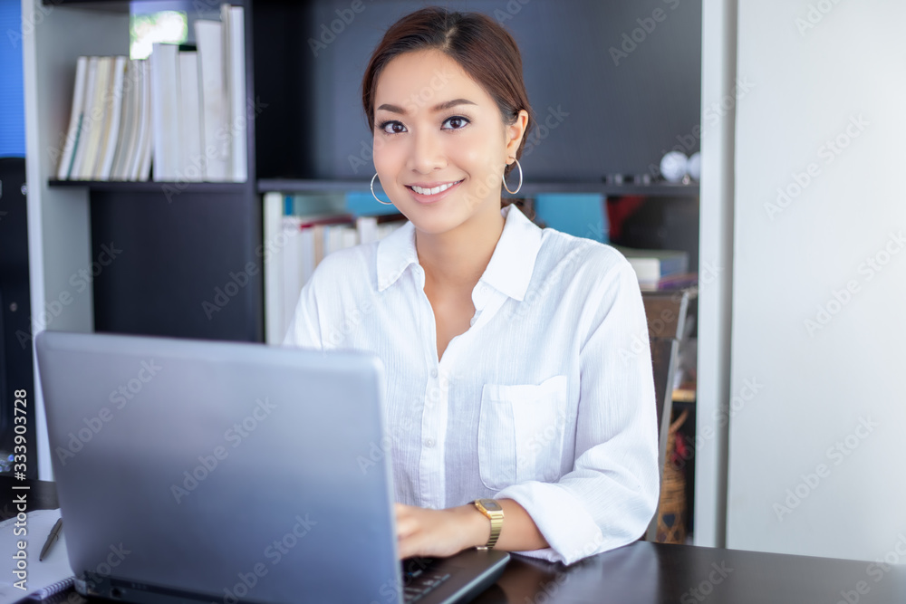 Beautiful Asian business women checking document and using notebook for working at home Beautiful Asian business women checking document and using notebook for working at home