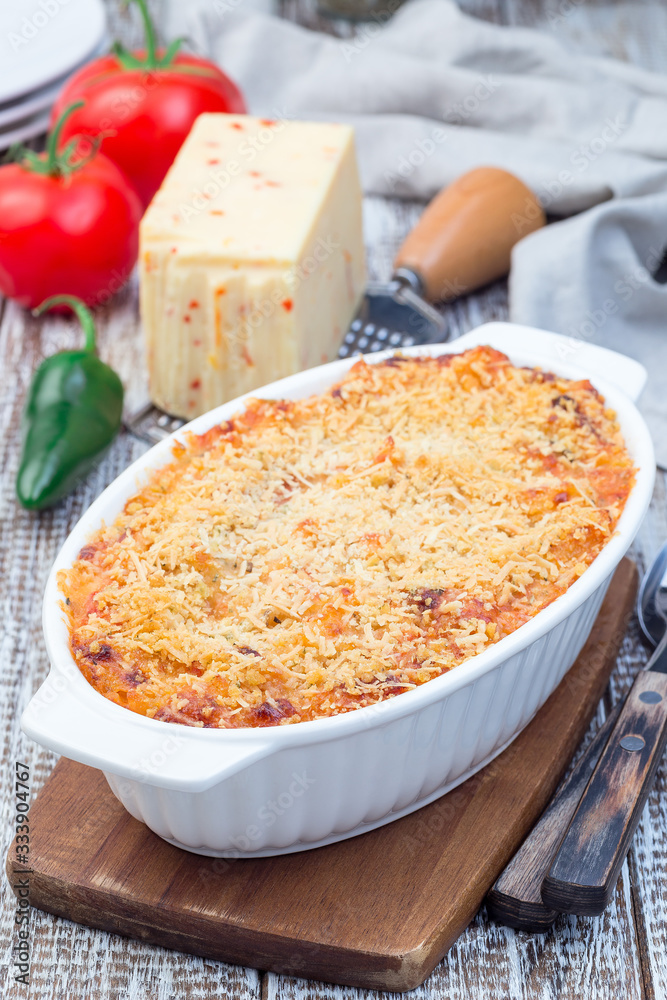 Spicy tomato jalapeno mac and cheese with mini penne pasta, in a baking dish, vertical Spicy tomato jalapeno mac and cheese with mini penne pasta, in a baking dish, vertical
