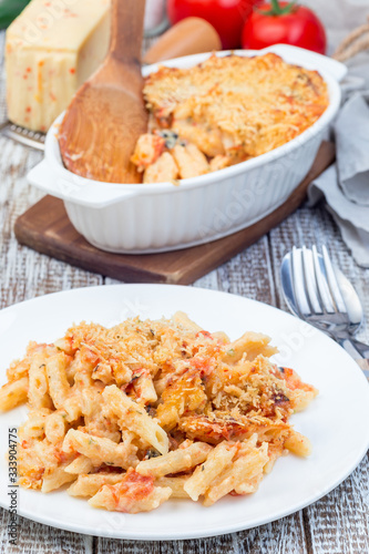 Spicy tomato jalapeno mac and cheese with mini penne pasta, on a plate, vertical photo