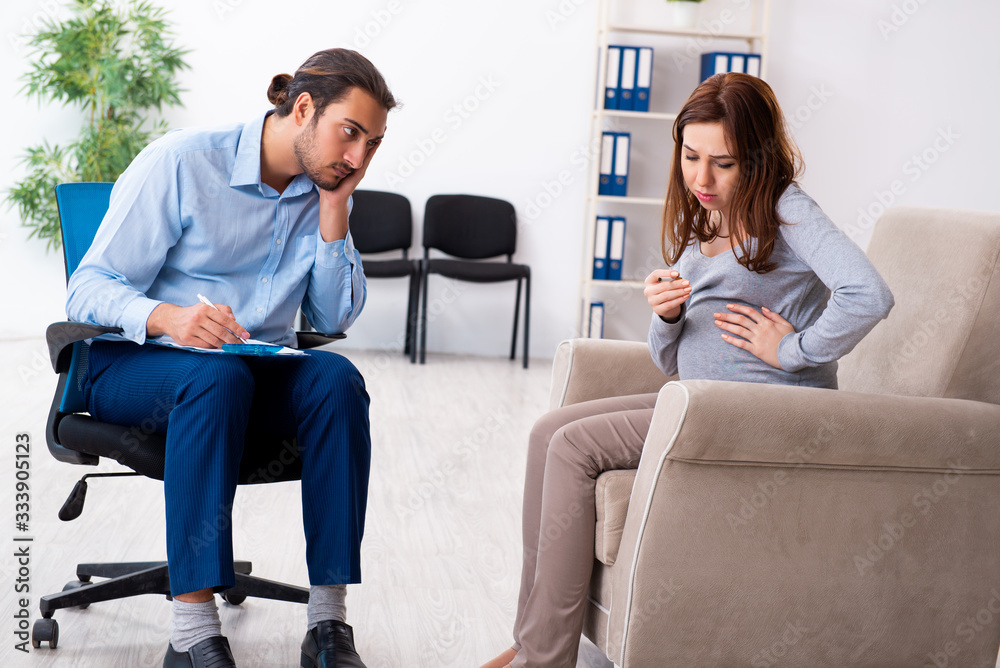 Pregnant woman visiting young male psychologist Pregnant woman visiting young male psychologist