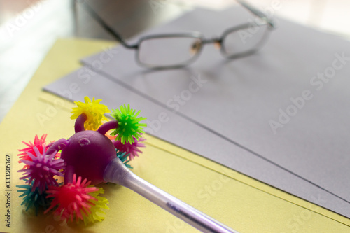 ballpoint pen with many colored pompoms on colored card photo