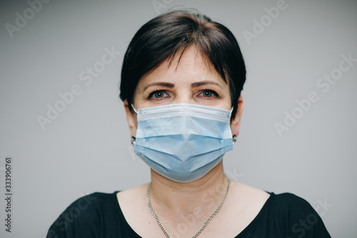 Woman Wearing Medical Mask During Coronavirus COVID-19 Epidemic. Sick woman wearing protection during pandemic. Pretty Caucasian Woman Taking on Medical Mask © uflypro