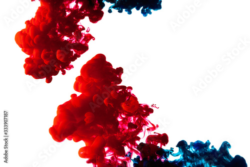 Red and blue ink splashes in water on white background. Abstract patterns of paints in water. 