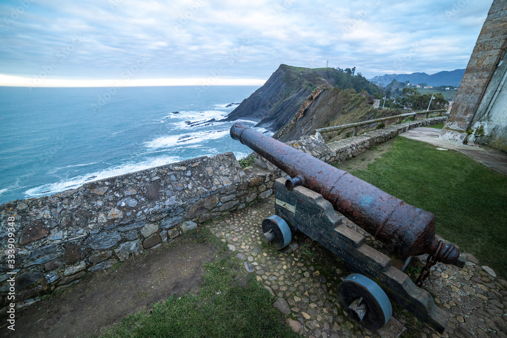 amazing landscape from a field of a cannon on the foreground and mountains and the sea on the background in the north of spin at the coast amazing landscape from a field of a cannon on the foreground and mountains and the sea on the background in the north of spin at the coast