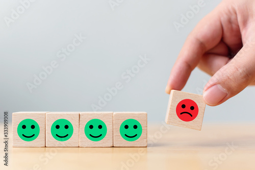 Wooden block with icon face emotion happiness and sadness, Unique, think different, individual and standing out from the crowd concept