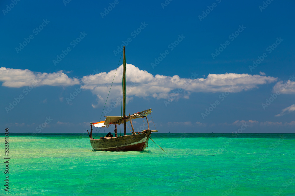 Old colorful african wooden boat on  ocean surface