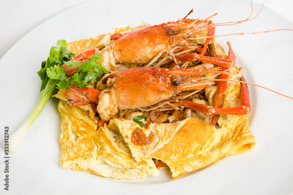 luxury stri fried thai noodle padthai noodle wrapped in omelet top with big prawn shrimps serve in white plate