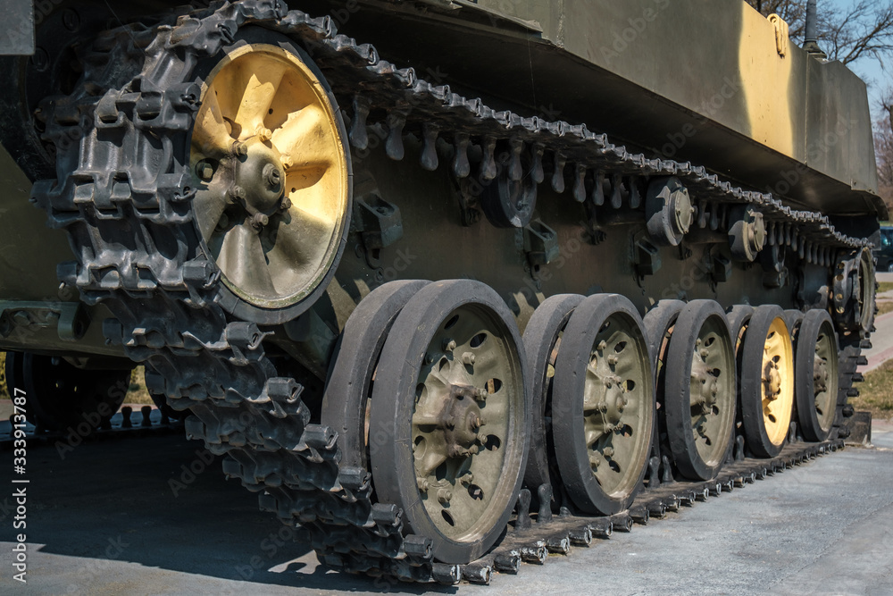 tracks and wheels of tank, armored vehicles on the street in green khaki color