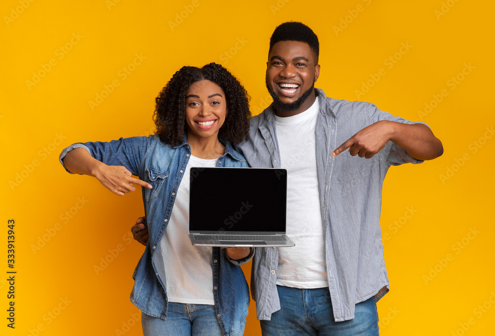 Great Website. Happy black couple pointing at laptop with black screen Great Website. Happy black couple pointing at laptop with black screen