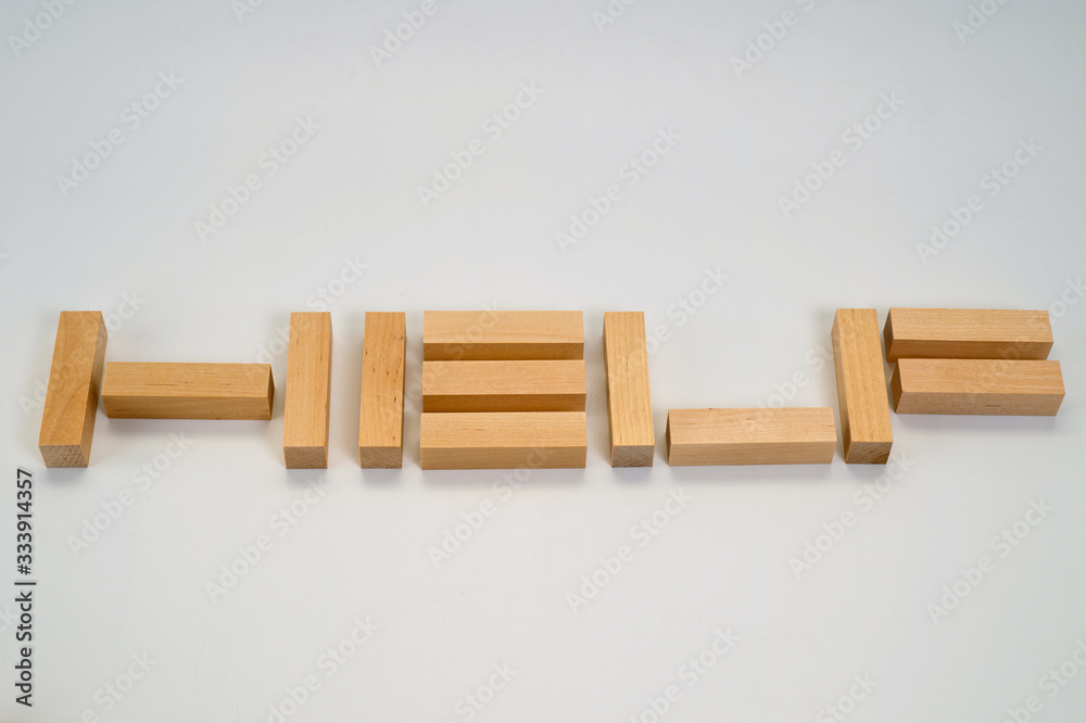 The word Help laid out by wooden blocks on a white background. Background to help those in need.