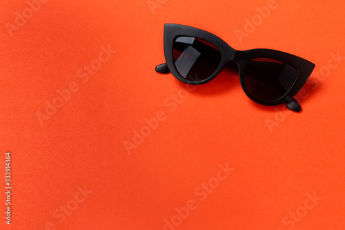 Fashionable sunglasses on an orange background.