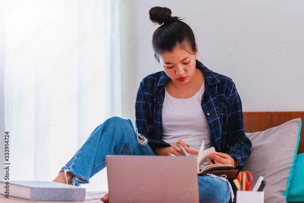 Asian businesswoman work from home with laptop and smartphone on bed in bedroom.Concept of social distancing is infection control action to stop the spread disease of Covid-19 Corona virus. Asian businesswoman work from home with laptop and smartphone on bed in bedroom.Concept of social distancing is infection control action to stop the spread disease of Covid-19 Corona virus.