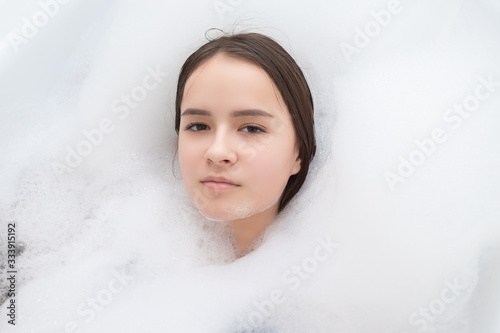 Beauty, spa, personal care. Young woman relaxes in the bath with foam
