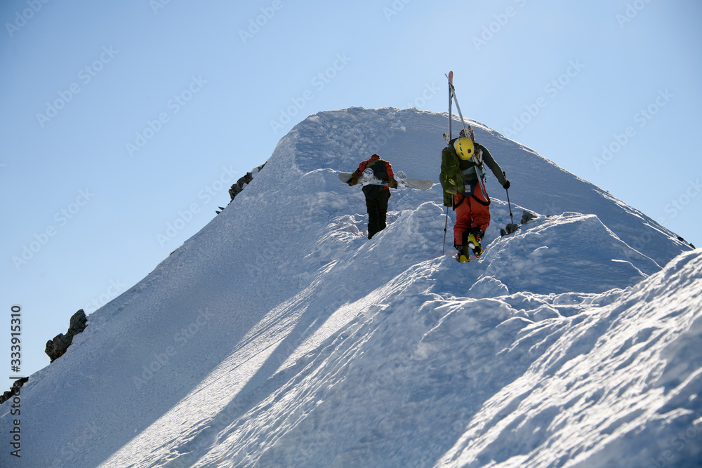 snowboarder and skier rises to the top of mountain