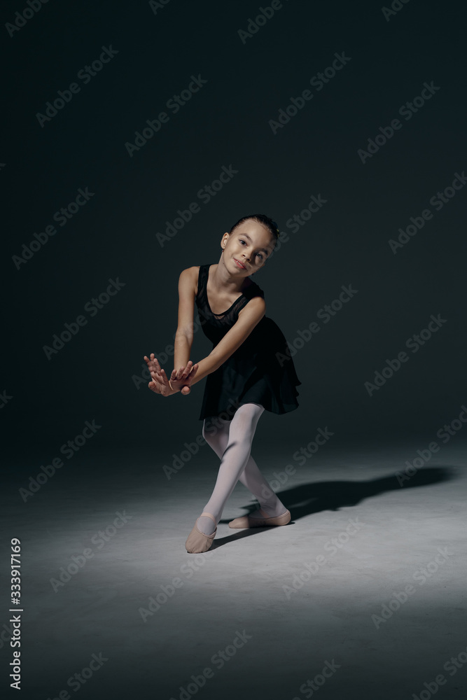 Delicate girl ballerina dancing in studio