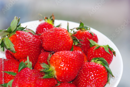 Fresh ripe strawberry at the white plate, banner with copyspace for a text