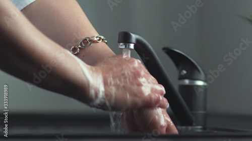 Washing hands with soap in sink to prevent corona virus  flu  hygiene to stop the spread of germs. Man s hand close up
