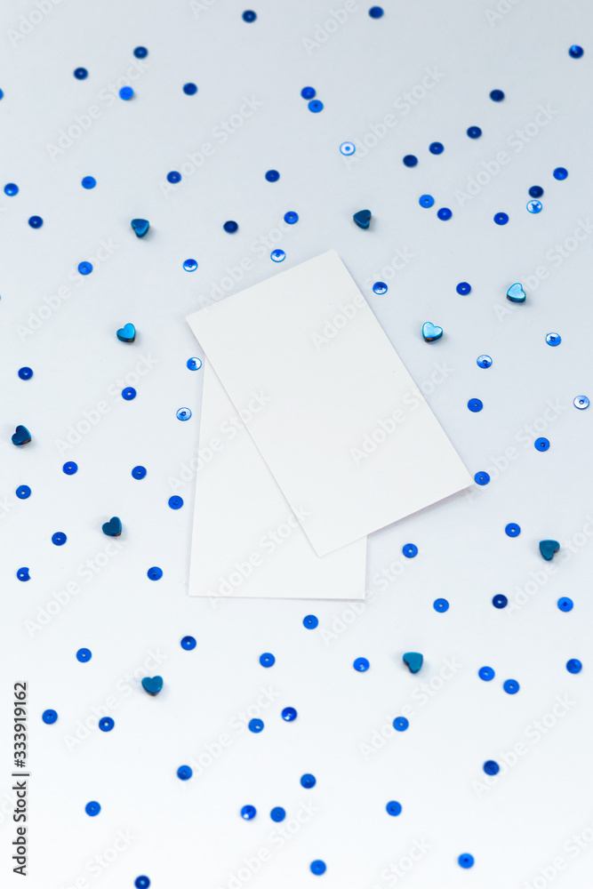 Stock Photo - Photo of blank card with blue sequins on paper background. For design presentations and portfolios. Stock Photo - Photo of blank card with blue sequins on paper background. For design presentations and portfolios.