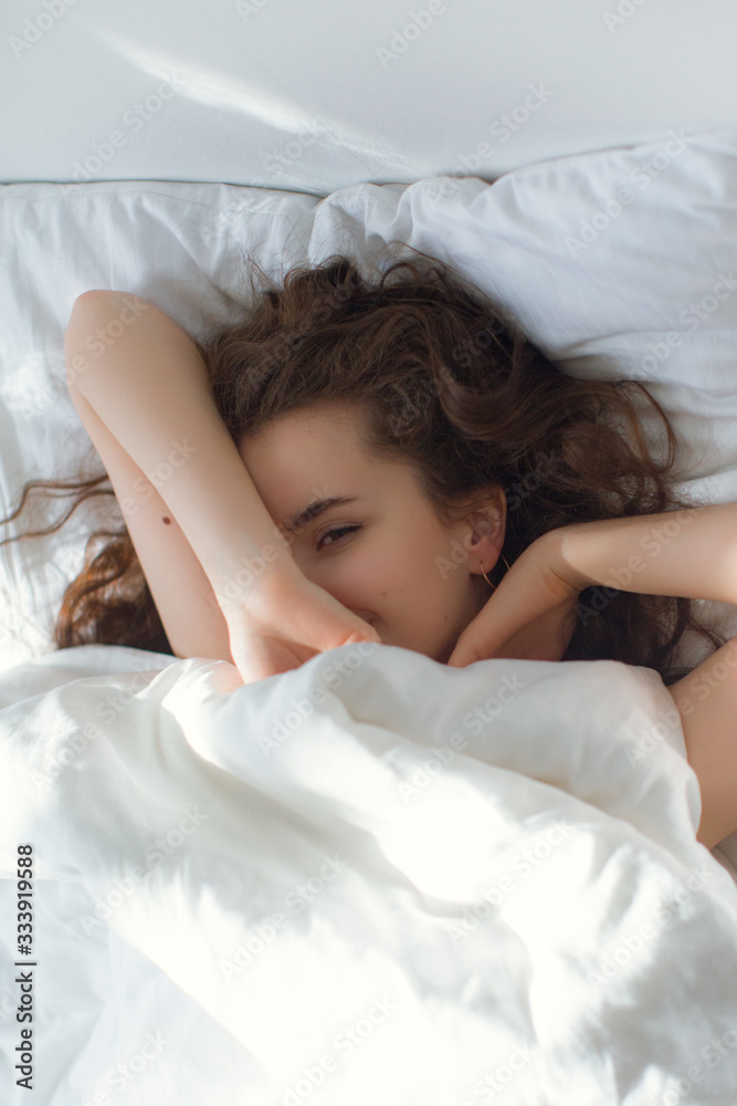 Stock photo - I stay at home awareness social media campaign and coronavirus prevention. Girl under the covers in her bed Stock photo - I stay at home awareness social media campaign and coronavirus prevention. Girl under the covers in her bed