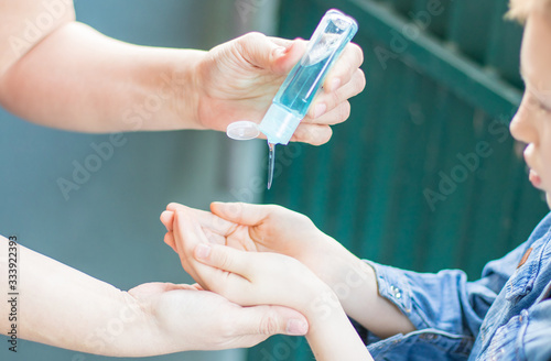 Coronavirus Mother and daughter using wash hand sanitizer gel. Protection germs on hands Covid-19 outbreak. stay at home